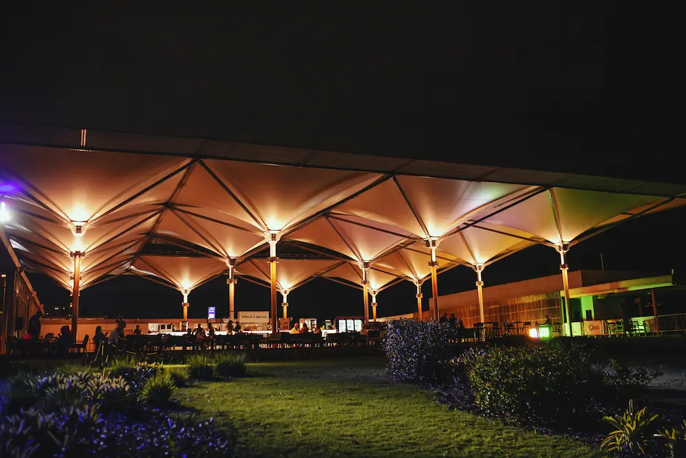 Deck coberto iluminado durante evento noturno no Golfe Olímpico
